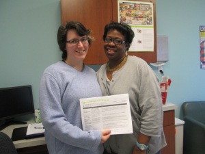 Shirley, on the right, shows off her insurance summary with Carina, on the left, following her completed enrollment this month. 